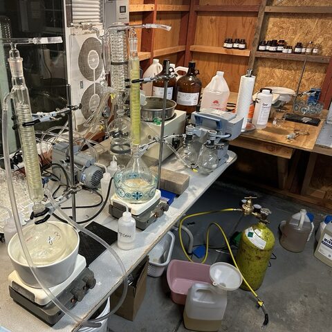 A home chemistry setup on folding tables in a garage